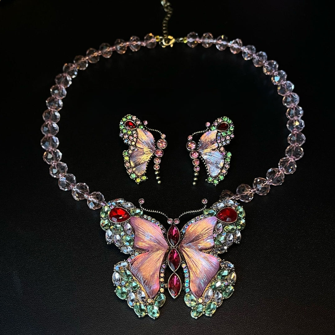 Butterfly-themed necklace and earrings set on a black background