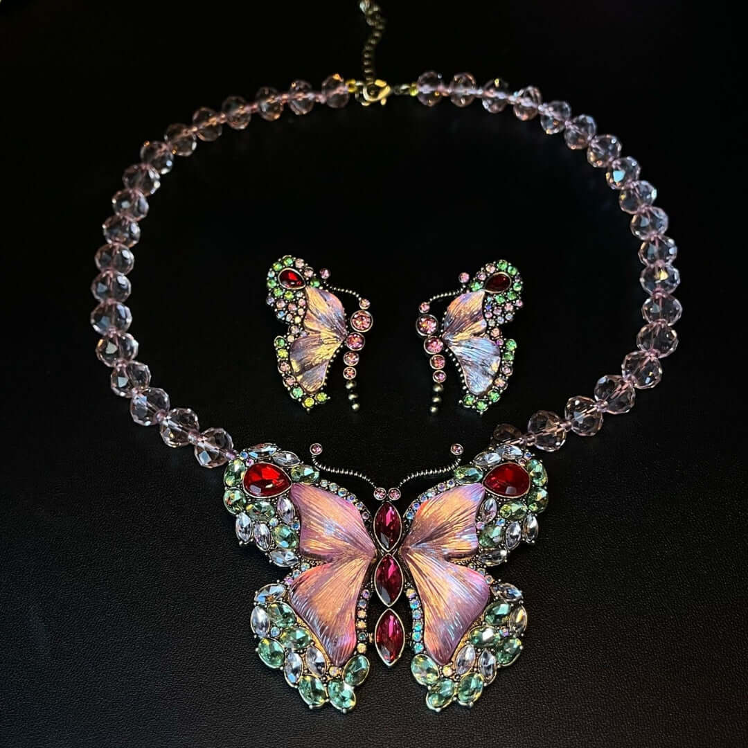 Butterfly-themed necklace and earrings set on a black background