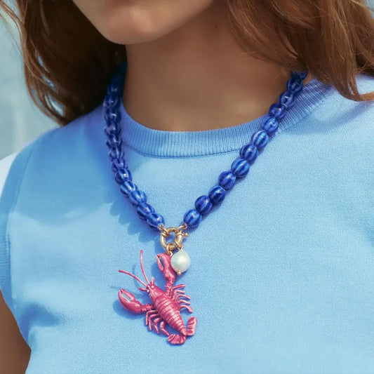 Person wearing a pink lobster charm necklace