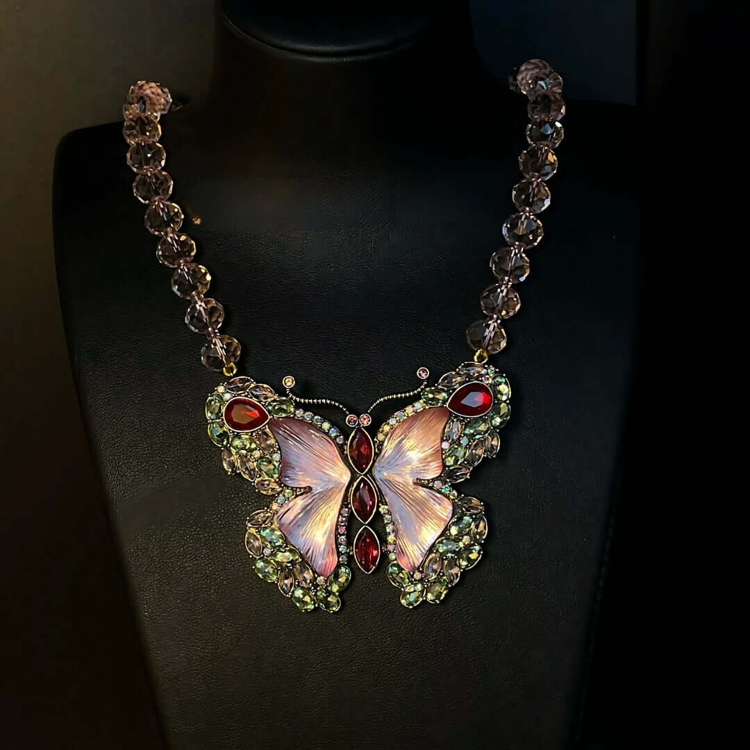 Butterfly-shaped necklace with gemstones on a black background