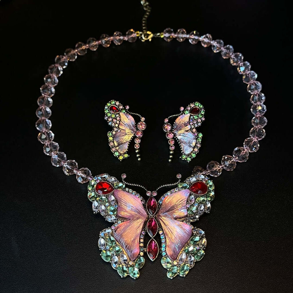 Butterfly-themed necklace and earrings set on a black background