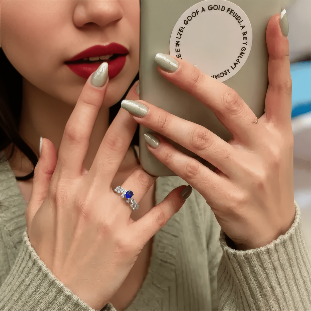 Close-up of a woman's hands holding a phone with a Sapphire September Pave Ring