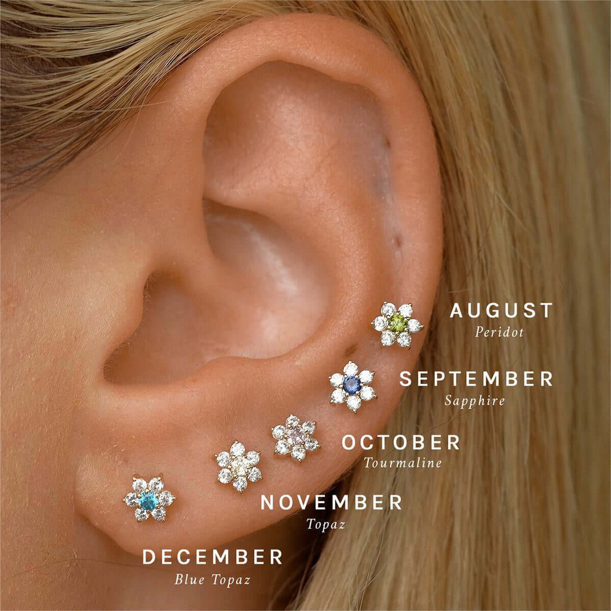 14K gold floral birthstone cartilage earrings for August, September, October, November, and December shown on ear. Ideal for helix and daith piercings.