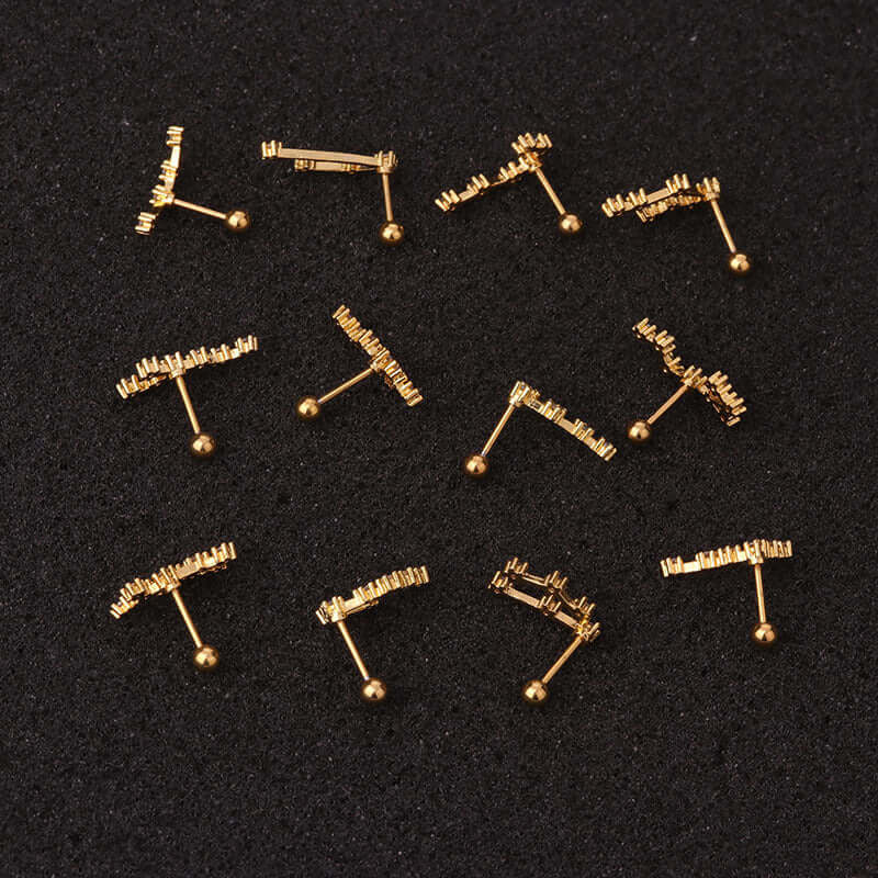 Gold zodiac cartilage stud earrings in various patterns on a black background, ideal for helix and daith piercings.