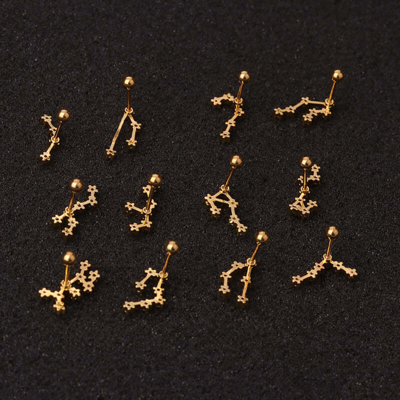 Gold zodiac cartilage stud earrings made from surgical steel, ideal for helix and daith piercings, displayed on a black background.