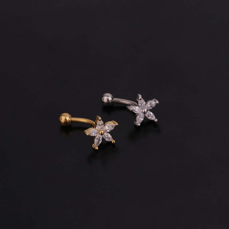 Gold and silver daith cartilage earrings with star pattern and CZ stones displayed on black background