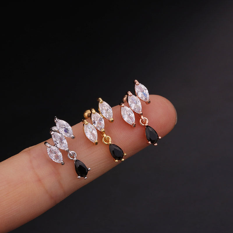 Silver, gold, and rose gold cartilage dangle stud earrings with CZ crystals displayed on a finger