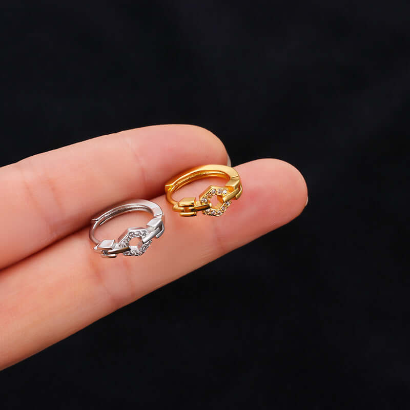 18K Gold and Silver Cross Cartilage Hoop Huggies held between fingers, SKU HSPJ794-1, ideal for helix and daith piercings.