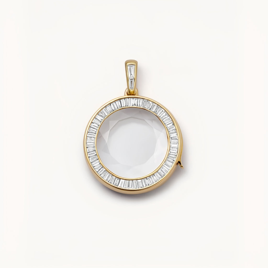 Gold pendant with a clear stone on a white background