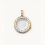 Gold pendant with a clear stone on a white background