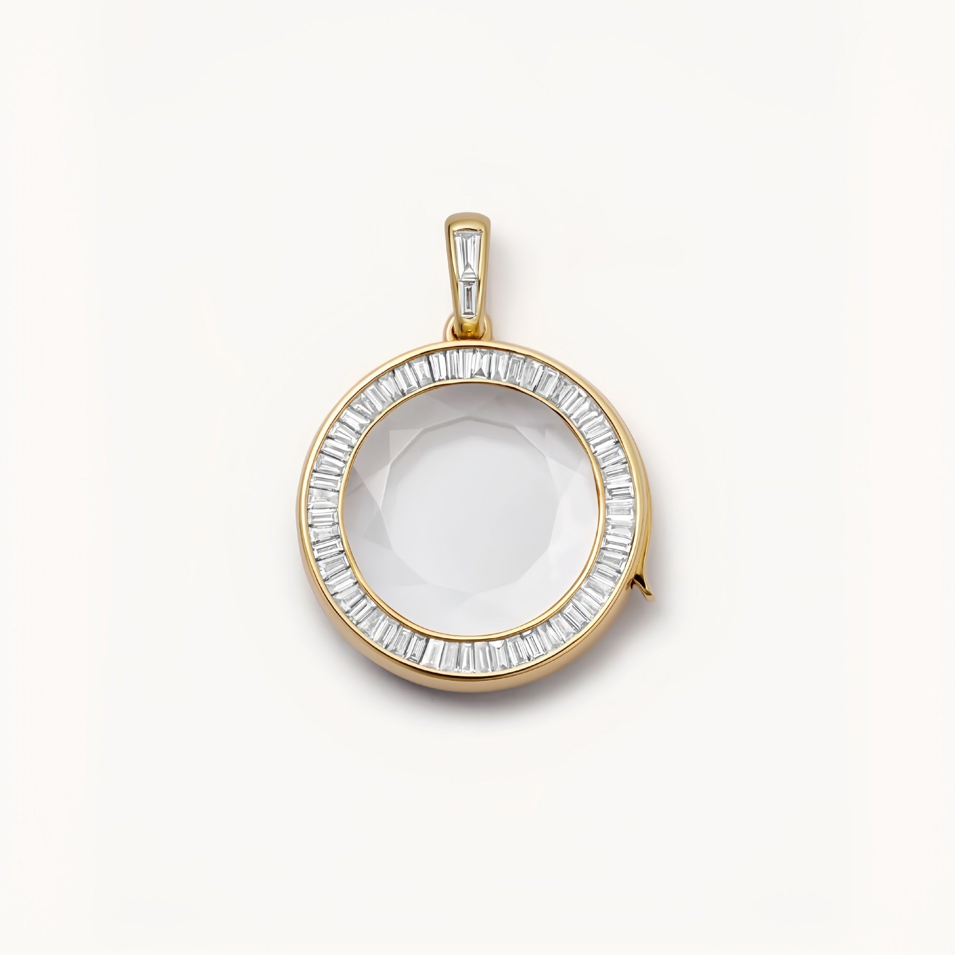 Gold pendant with a clear stone on a white background