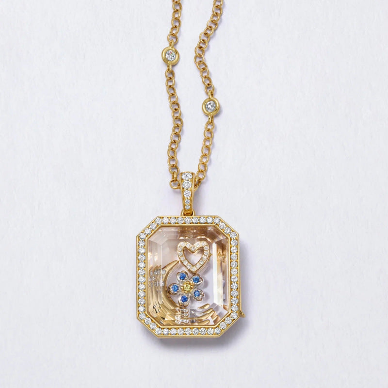 Gold necklace with a pendant featuring a heart and boot design on a light gray background