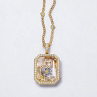 Gold necklace with a pendant featuring a heart and boot design on a light gray background