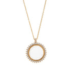 Gold necklace with a round pendant on a white background