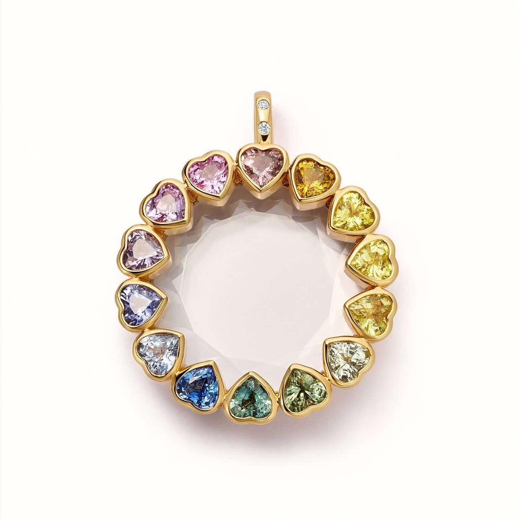 Gold pendant with heart-shaped multicolored gemstones on a white background