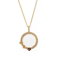 Gold necklace with a round pendant featuring gemstones on a white background