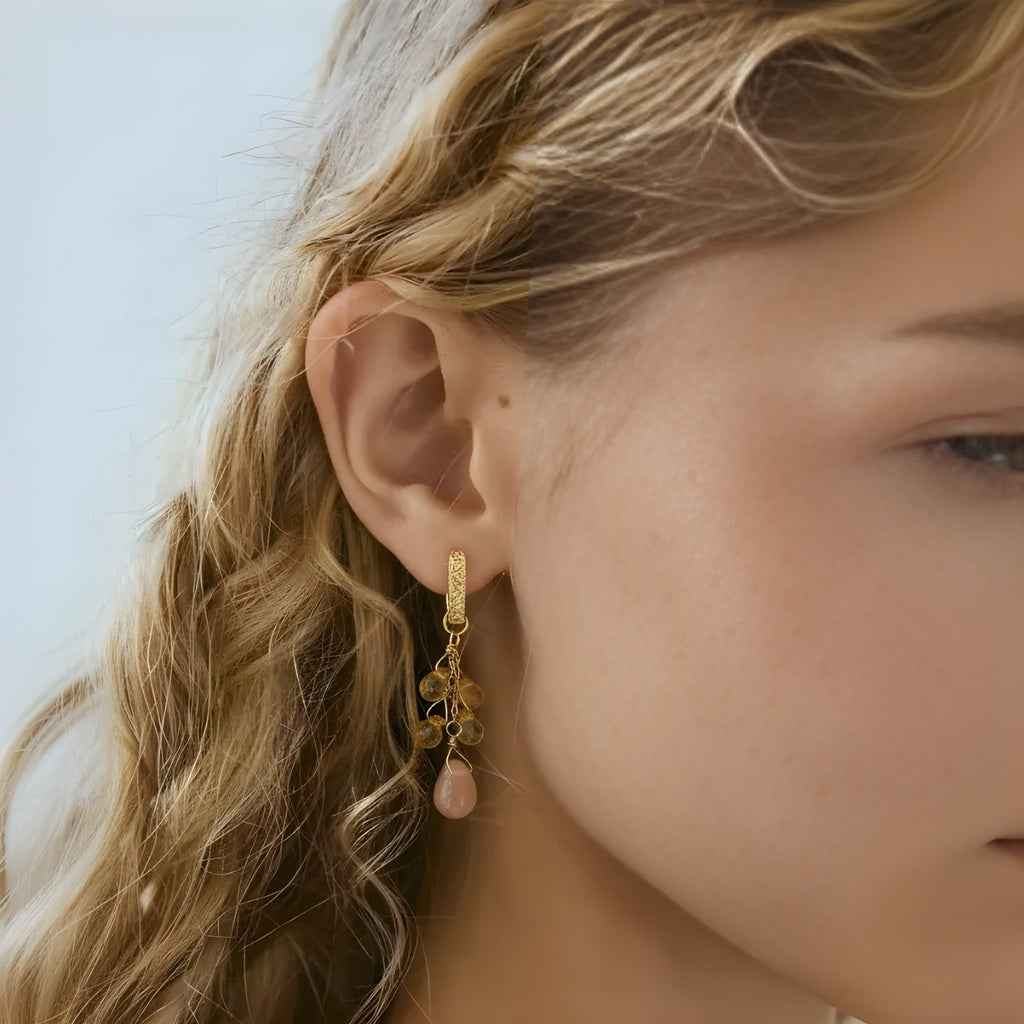 Close-up of a person wearing a sunstone drop earrings